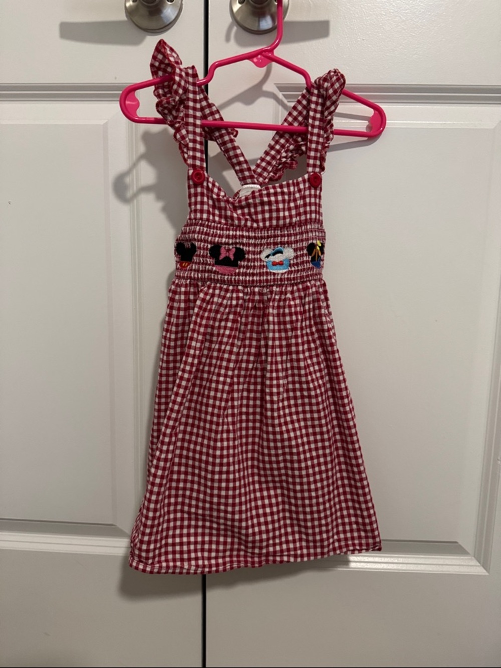 Smocked, gingham dress with embroidered Disney characters.